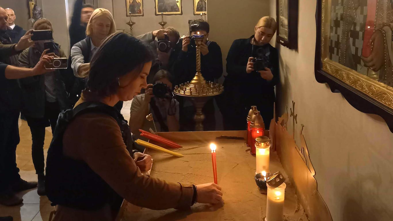 Baerbock zündet eine Kerze für die Opfer in einer Kirche in Butscha an: Der Ort war einen Monat lang von russischen Truppen besetzt.