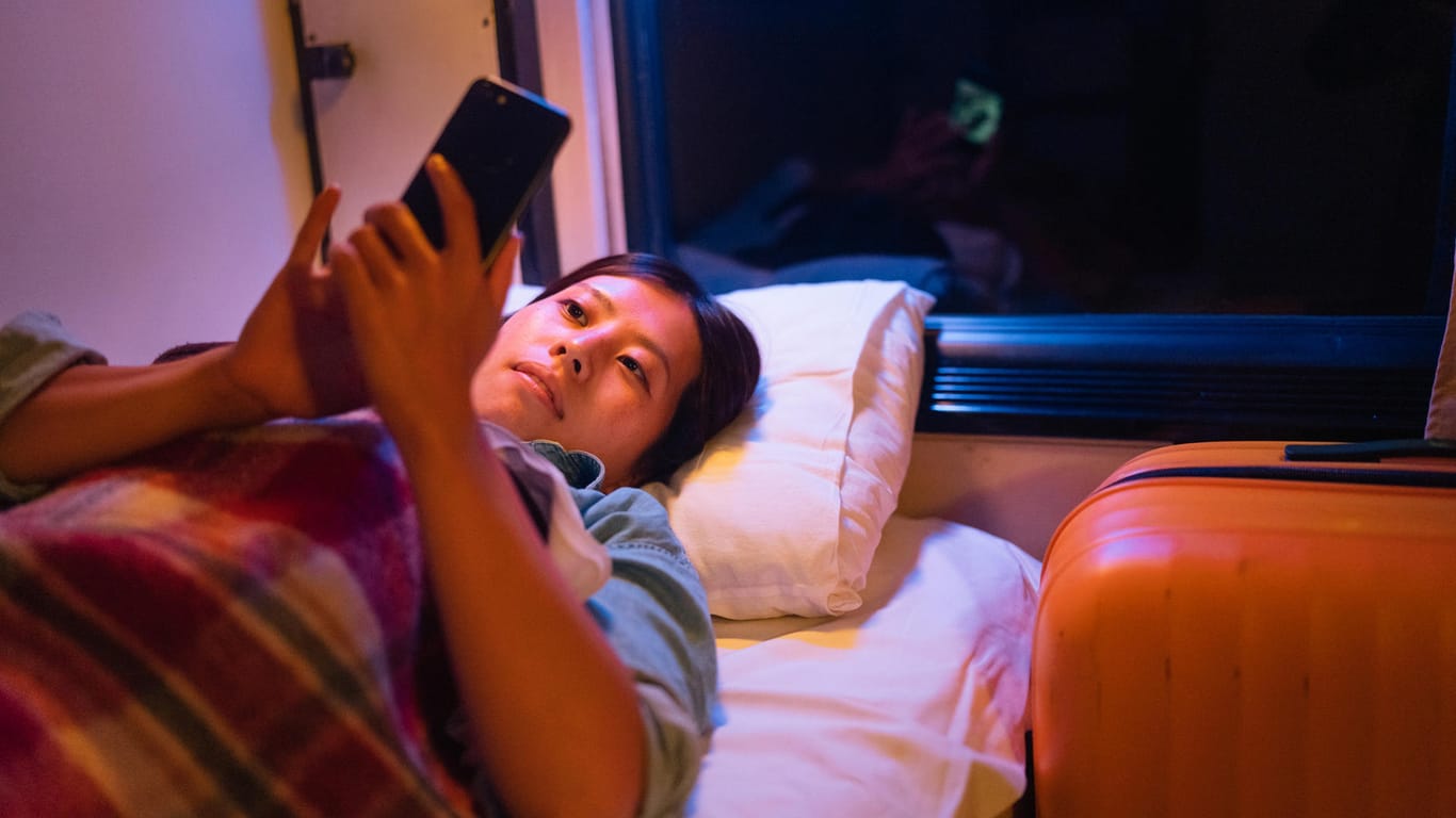 Eine Frau liegt in der Kabine eines Nachtzuges: Durch Nachtzüge kann man im Schlaf sein Ziel erreichen.