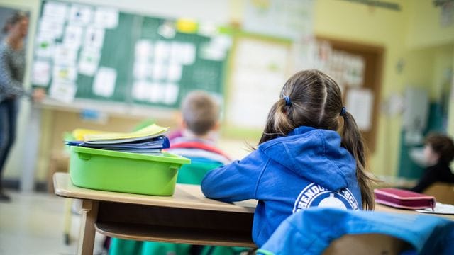 Schülerinnen und Schüler einer Grundschule sitzen in ihrem Klassenraum. Schülerinnen und Schüler einer Grundschule sitzen in ihrem Klassenraum.