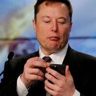 Elon Musk schaut auf sein Handy: "War gut, euch gekannt zu haben".