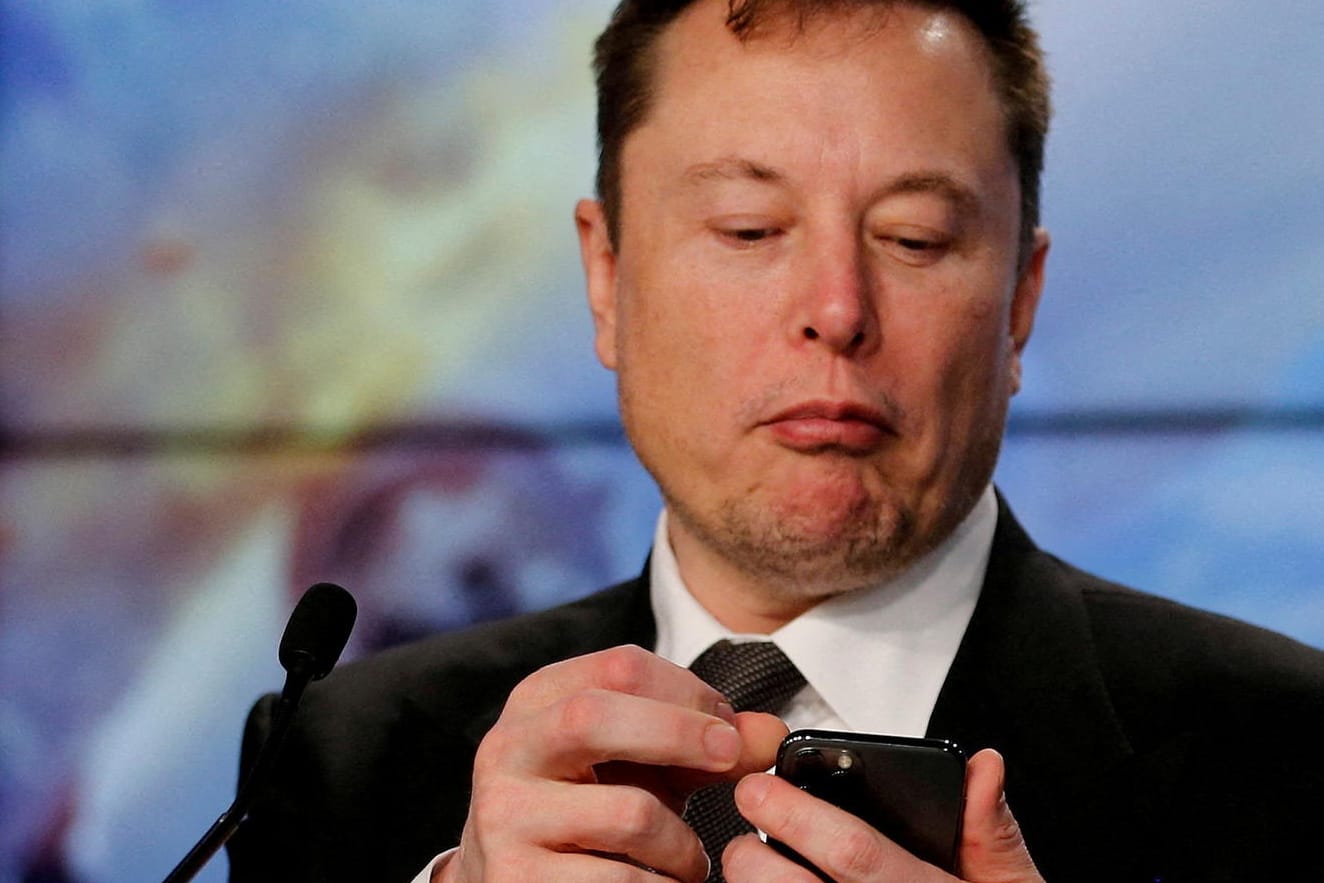 Elon Musk schaut auf sein Handy: "Wenn ich unter geheimnisvollen Umständen sterben sollte – war gut, euch gekannt zu haben."