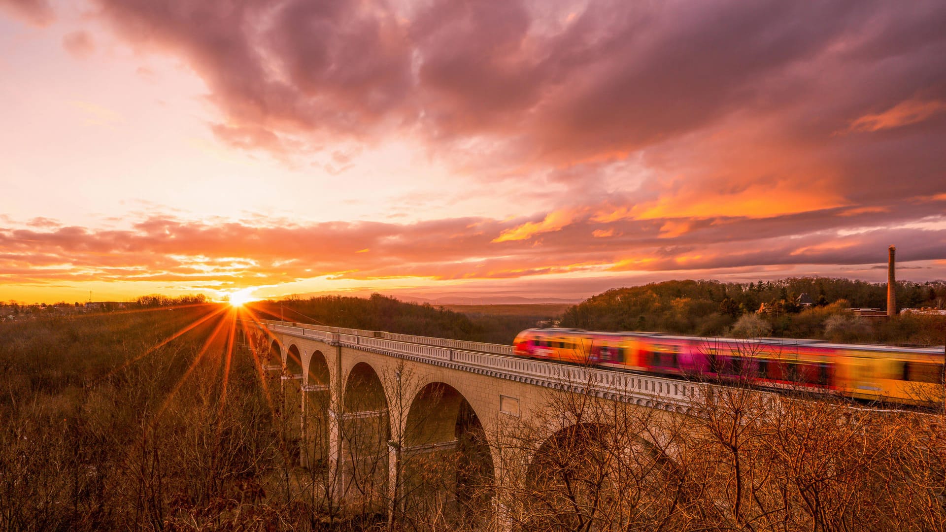 Eine Regionalbahn fährt in den Sonnenaufgang nahe der sächsischen Stadt Görlitz: Mit dem 9-Euro-Ticket können viele schöne Ausflugsziele erreicht werden.