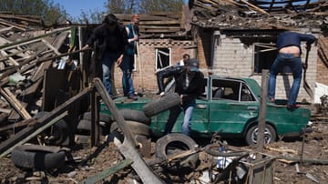 Bachmut: Einwohner entfernen Trümmer vor einem Haus nach einem russischen Luftangriff in Bachmut in der Oblast Donezk in der Ostukraine.
