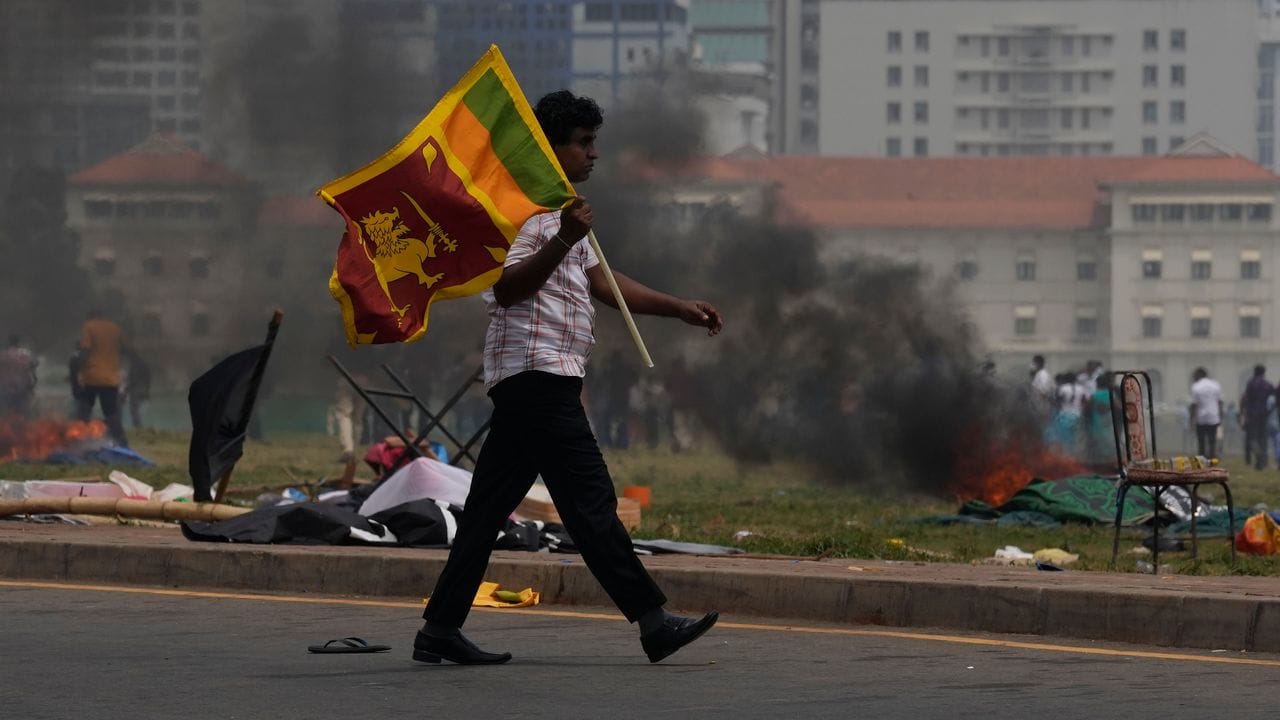 Ein Unterstützer der srilankischen Regierung trägt eine Nationalfahne.