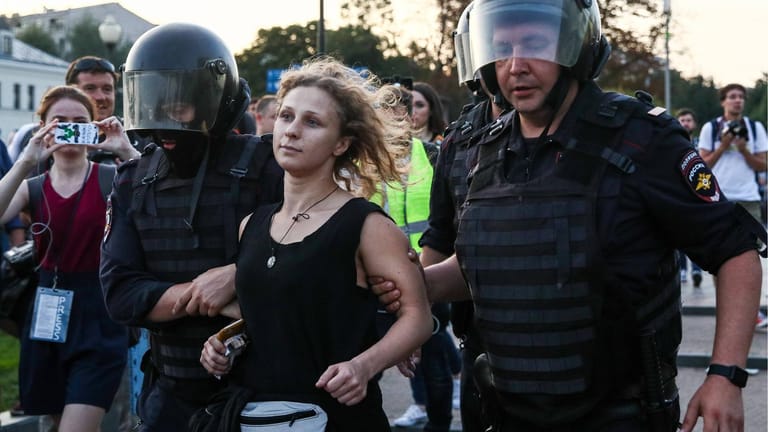 Maria Aljochina zwischen zwei Sicherheitskräften (Symbolbild): Die 33-Jährige setzt sich für Freiheitsrechte in Russland ein.