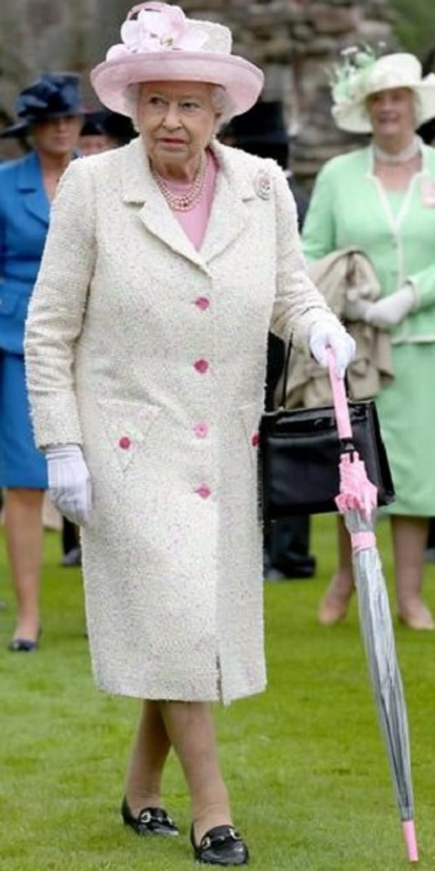 Gartenparty: Hier trägt die Queen etwas gedecktere Farben, pinke Akzente sorgen aber für einen Hingucker.