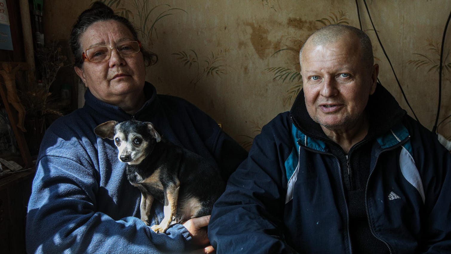 Olga, Michail und ihr Hund Isja in ihrer Wohnung in Charkiw.