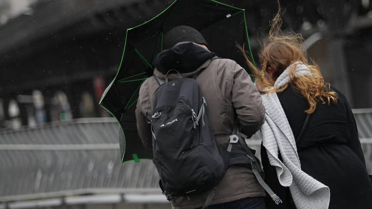Ein Mann und eine Frau schützen sich mit einem Regenschirm (Symbolbild): In den kommenden Tagen soll das Wetter wechselhaft werden.