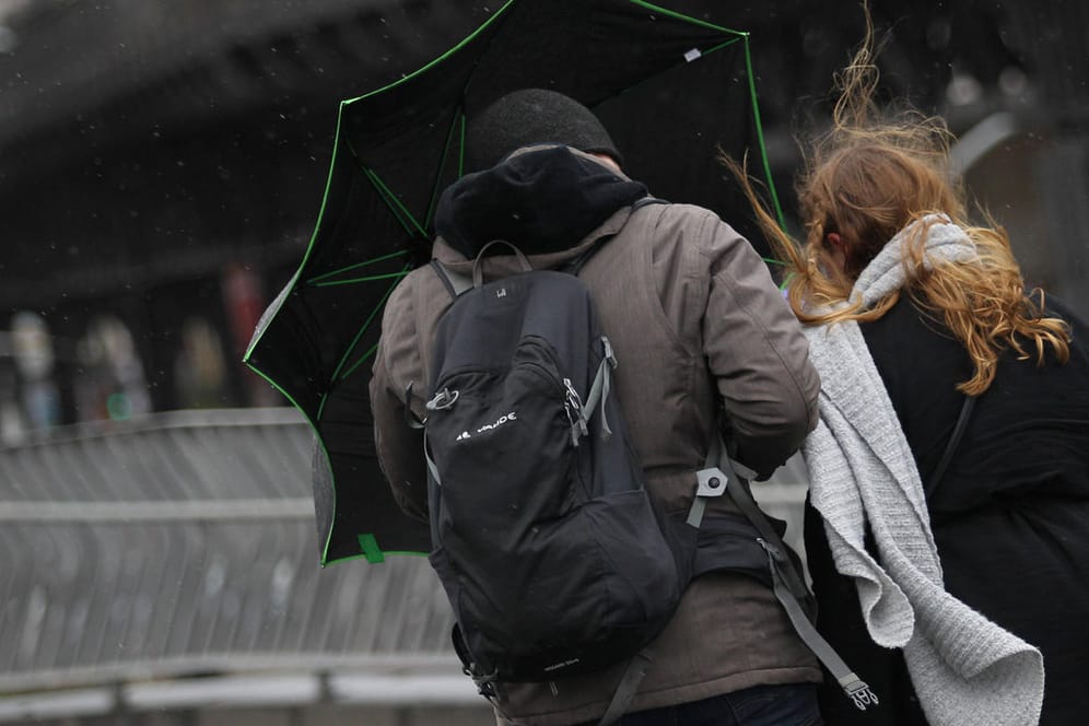 Ein Mann und eine Frau schützen sich mit einem Regenschirm (Symbolbild): In den kommenden Tagen soll das Wetter wechselhaft werden.