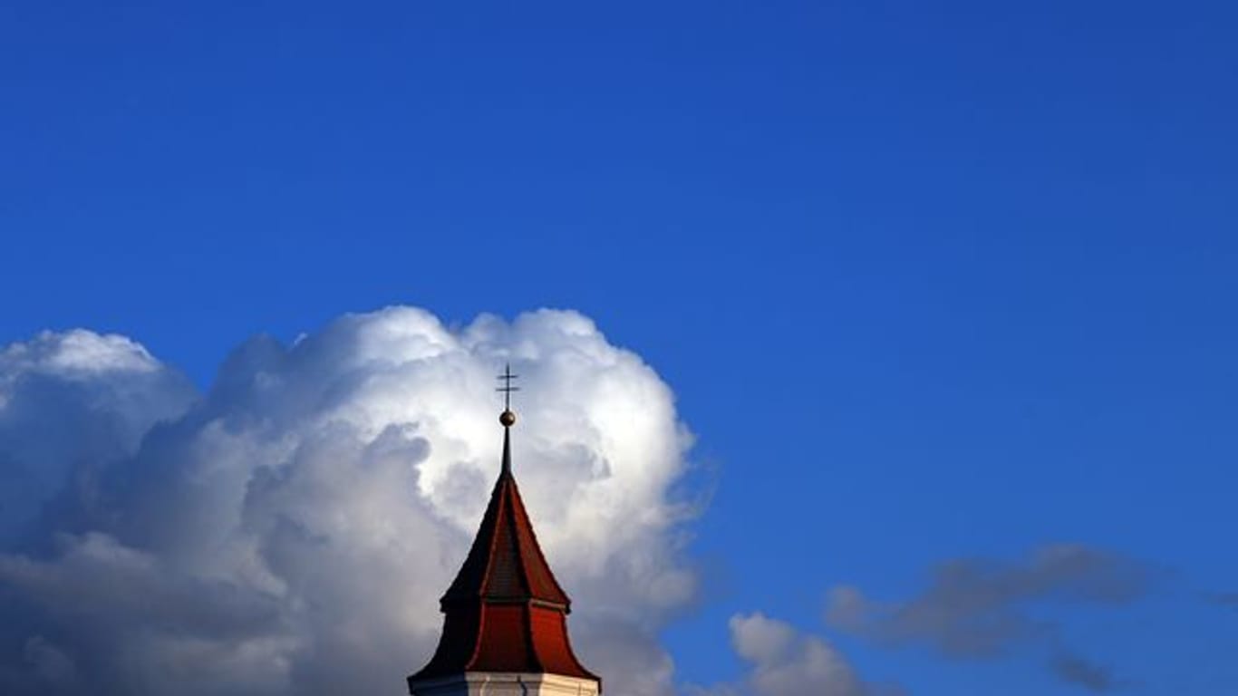 Wolken türmen sich über Kirchturm