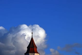 Wolken türmen sich über Kirchturm