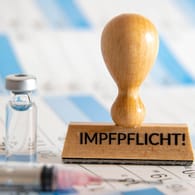 Stempel mit der Aufschrift Impfpflicht auf einem Kalender (Symbolbild): Bayern will nur 300 Bußgeld wegen Impfpflichtverstößen.