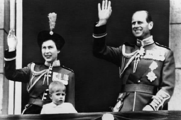 Die Queen und Prinz Philip – beide in Uniform – winken in den Sechzigerjahren vom Balkon des Buckingham-Palastes.