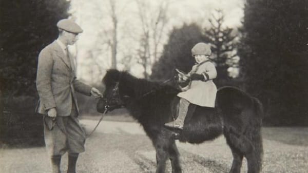 Mai 1930: Die Queen als junges Mädchen auf einem Shetlandpony, neben ihr steht ihr Vater.