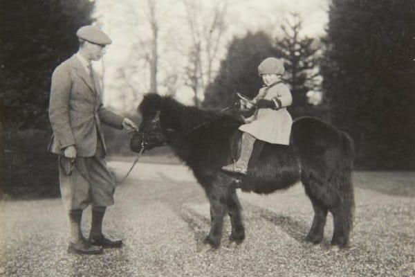 Mai 1930: Die Queen als junges Mädchen auf einem Shetlandpony, neben ihr steht ihr Vater.