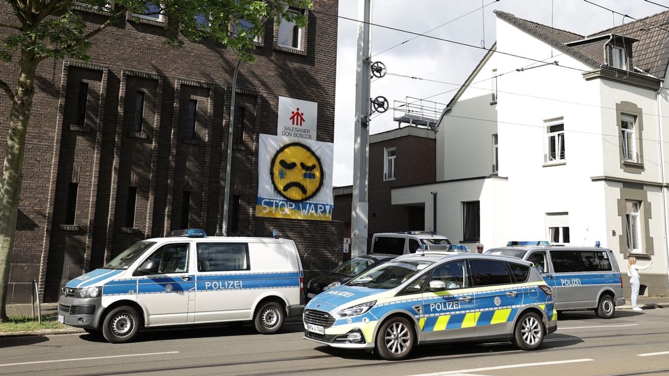 Polizeifahrzeuge stehen vor dem Don-Bosco-Gymnasium in Essen.