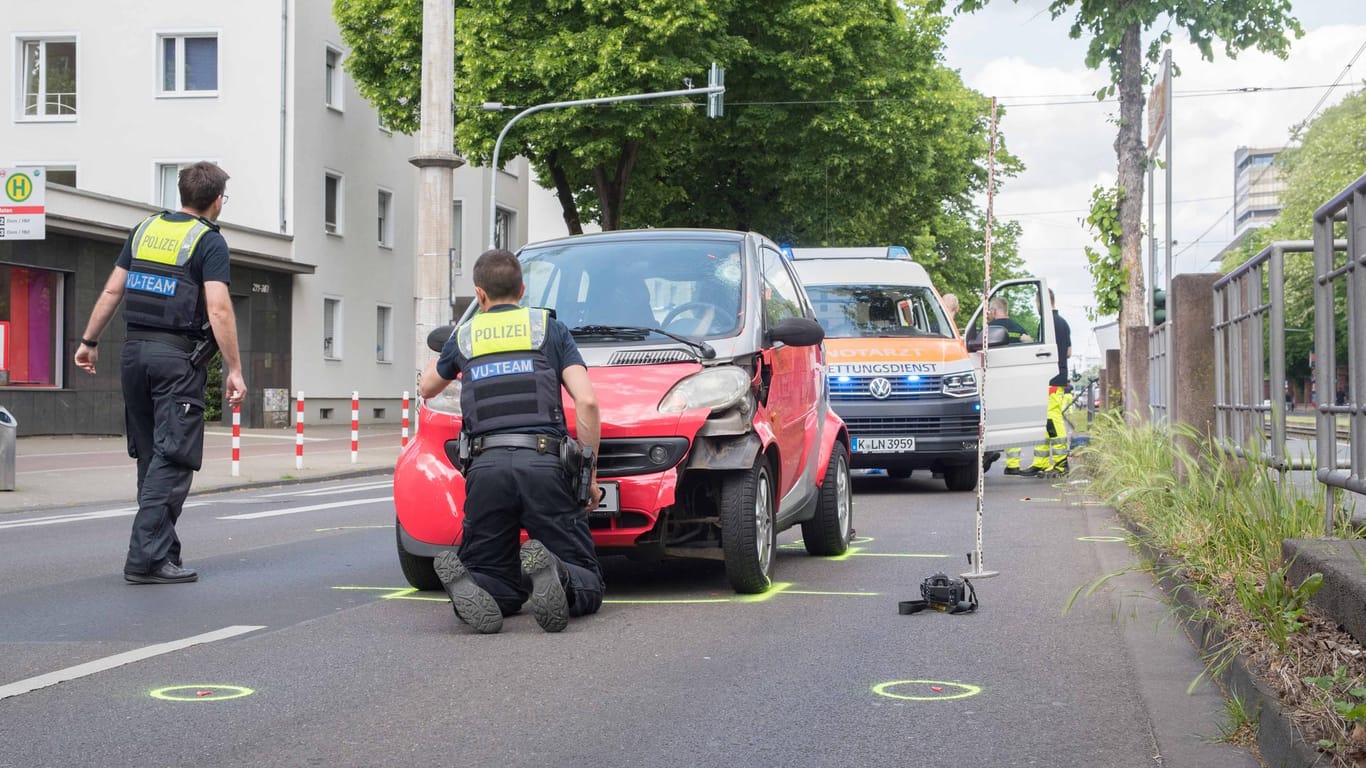 Die Polizei am Unfallort mit dem Unfallauto: In Köln ist eine 43 Jahre alte Fußgängerin gestorben.