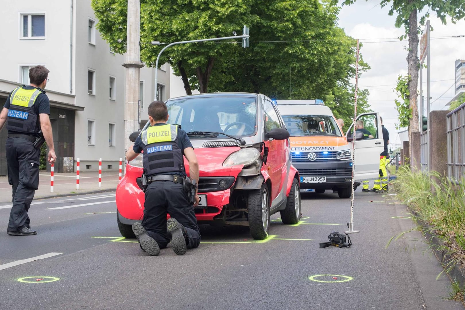 Die Polizei am Unfallort mit dem Unfallauto: In Köln ist eine 43 Jahre alte Fußgängerin gestorben.