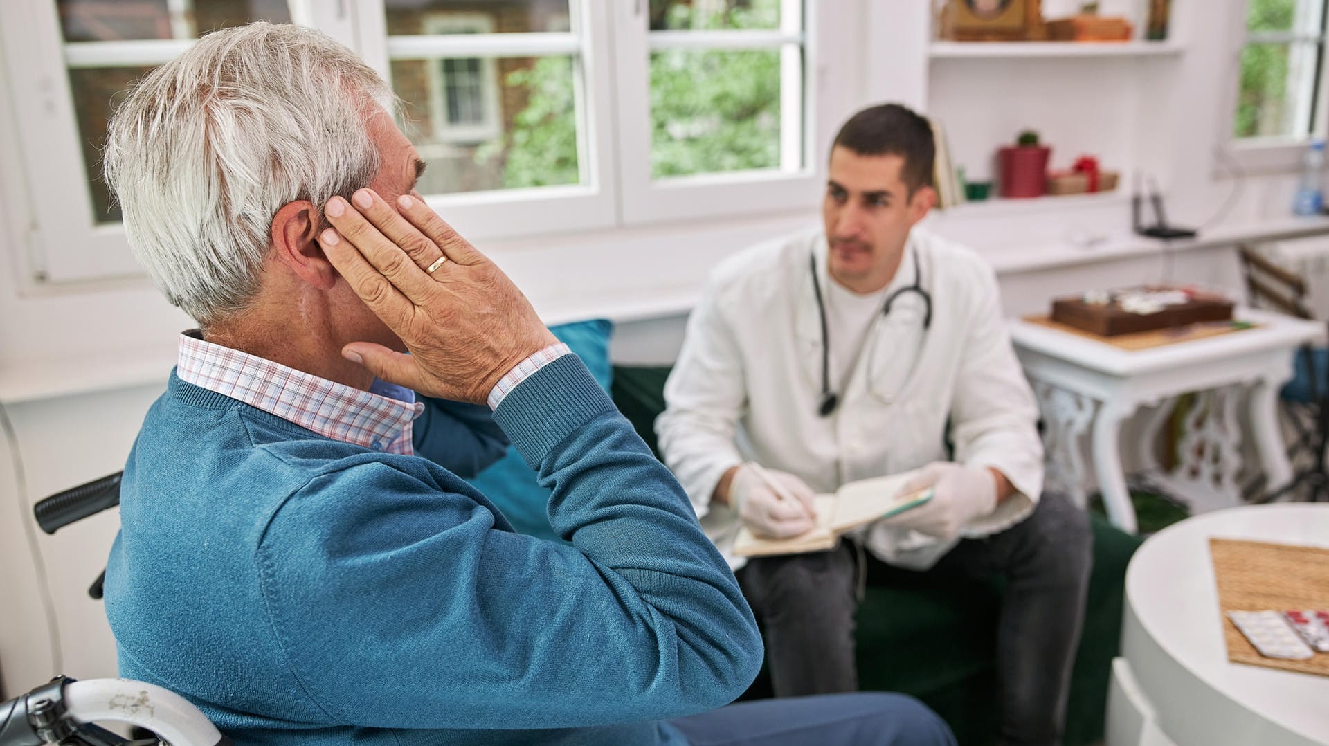 Senior mit Ohrproblemen beim Arzt.