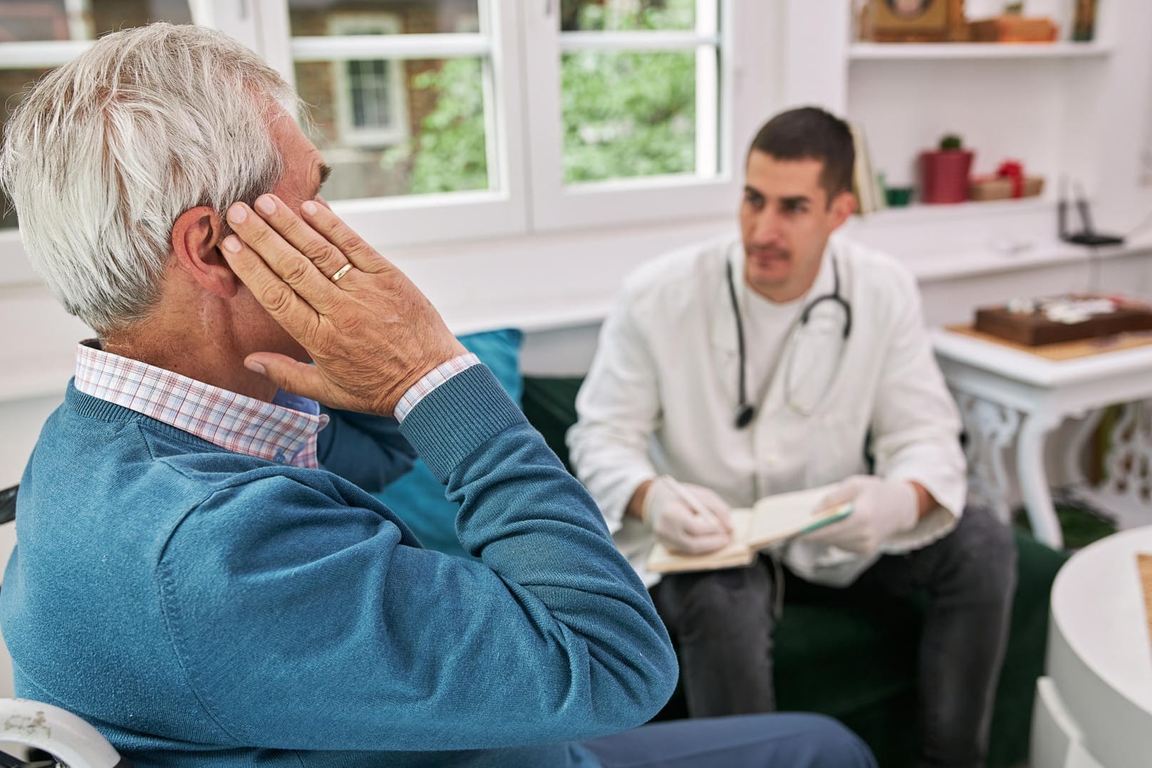 Senior mit Ohrproblemen beim Arzt.