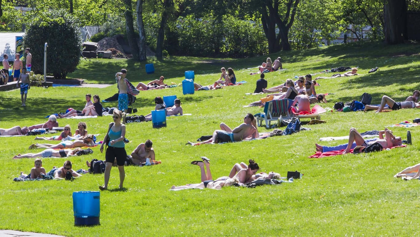 Menschen liegen Freibadwiese (Symbolbild): In Hamburg wird am Freitag die Badesaison eröffnet.