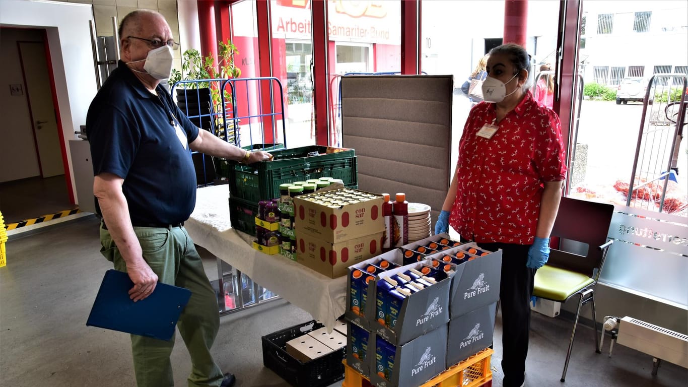 Horst Lantsch (links) und eine Helferin stehen vor einem Tisch in einer Lebensmittelausgabestelle des ASB: Vor allem haltbare Produkte sind derzeit Mangelware.
