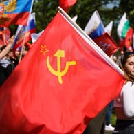 Junge Frau mit Sowjetflagge. Über 1000 Menschen drückten Anfang Mai in Köln ihre Unterstützung für Russland ausgedrückt.