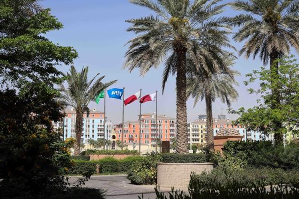 Die Flaggen Katars und der FIFA wehen vor einer Hotelanlage in Doha.