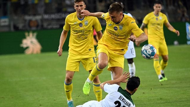 Gladbachs Rami Bensebaini (r) und Sergii Sydorchuk aus der Ukraine kämpfen im Benefizspiel um den Ball.