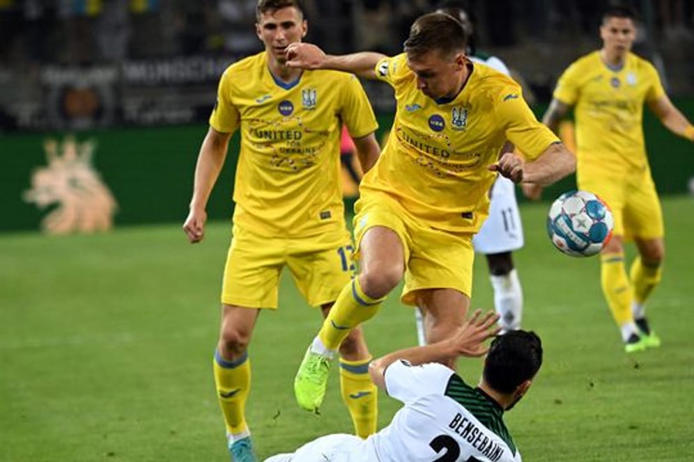 Gladbachs Rami Bensebaini (r) und Sergii Sydorchuk aus der Ukraine kämpfen im Benefizspiel um den Ball.