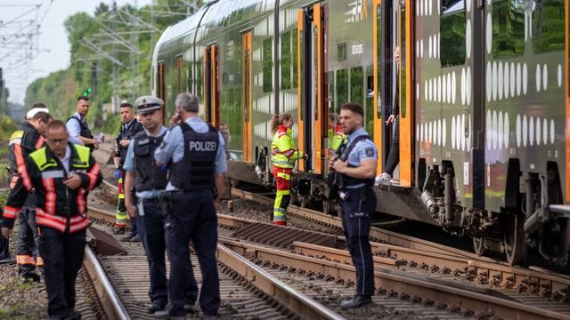 Polizisten und Rettungskräfte stehen vor dem Regionalexpress