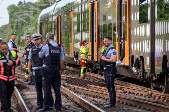 Polizisten und Rettungskräfte stehen vor dem Regionalexpress