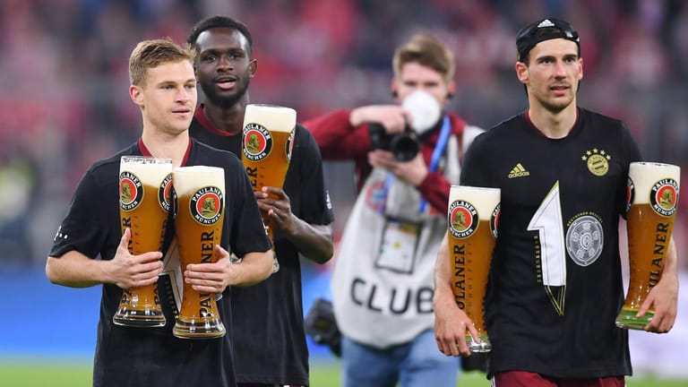 Joshua Kimmich, Tanguy Nianzou und Leon Goretzka (von links) feiern die Meisterschaft des FC Bayern mit Weißbier (Archivbild): Auch beim zehnten Titel in Folge brach bei der Feier keine Ekstase aus.