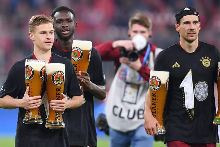 Joshua Kimmich, Tanguy Nianzou und Leon Goretzka (von links) feiern die Meisterschaft des FC Bayern mit Weißbier (Archivbild): Auch beim zehnten Titel in Folge brach bei der Feier keine Ekstase aus.
