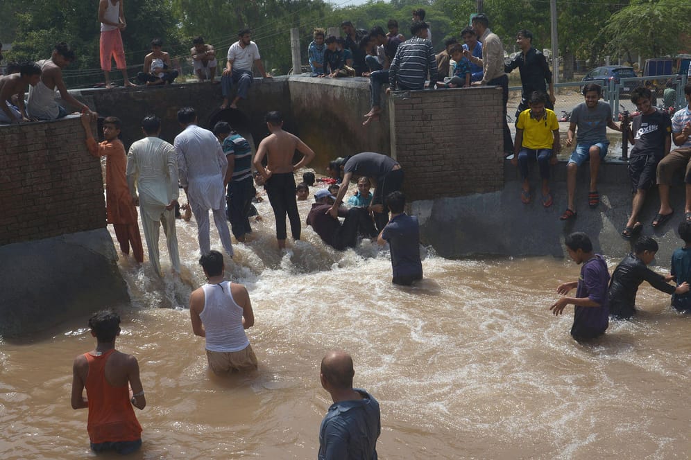Hohe Temperaturen in Lahore: Die Menschen in der pakistanischen Stadt suchen in Kanälen nach etwas Abkühlung von der Hitzewelle.