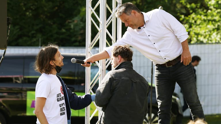 Habeck hält dem Demonstranten ein Mikrofon hin: Er ist offenbar Klima-Aktivist.