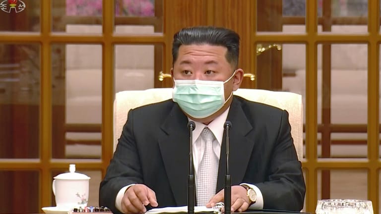 Kim Jong-un, Machthaber von Nordkorea, trägt während eines Treffens zur Bestätigung des ersten Corona-Falls im Land einen Mund-Nasen-Schutz.