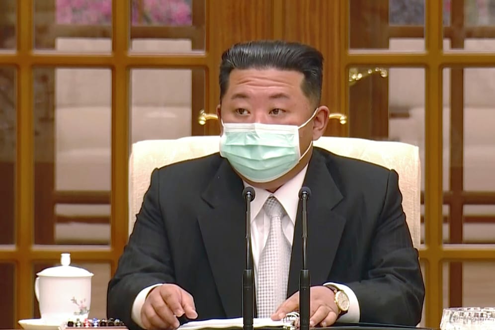 Kim Jong-un, Machthaber von Nordkorea, trägt während eines Treffens zur Bestätigung des ersten Corona-Falls im Land einen Mund-Nasen-Schutz.