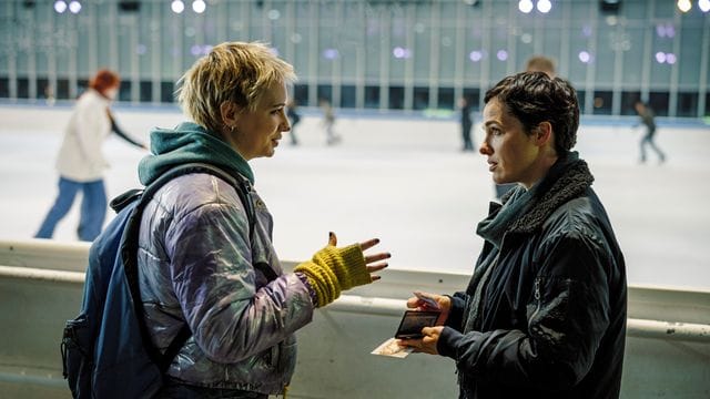 Bessie Eyckhoff (Verena Altenberger, r) befragt in der Eishalle Stefanie Reither (Zoë Valks) und zeigt ihr das Foto von Laura.