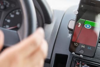Ein Autofahrer benutzt eine Grüne-Welle-App beim Fahren