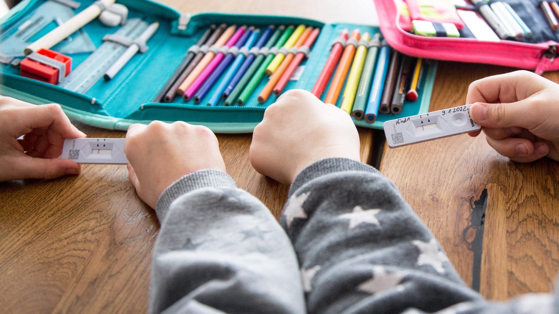 Zwei Schulkinder halten ihren Corona-Test in der Hand (Symbolbild): Die Schnelltests sollen ein freiwilliges Angebot bleiben. Zwei Schulkinder halten ihren Corona-Test in der Hand (Symbolbild): Die Schnelltests sollen ein freiwilliges Angebot bleiben.