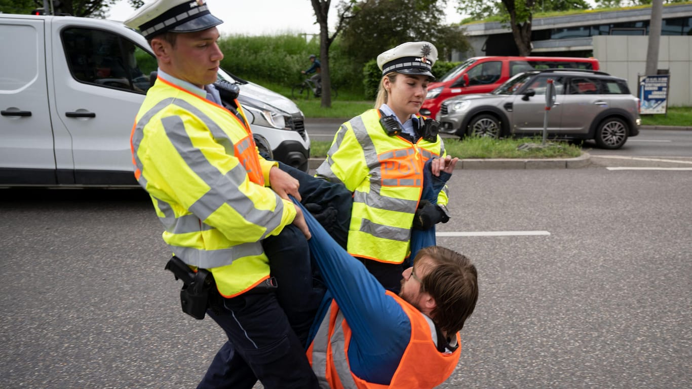 Einsatz in Stuttgart: Einer der Klimaaktivisten wird von Beamten von der Straße getragen.