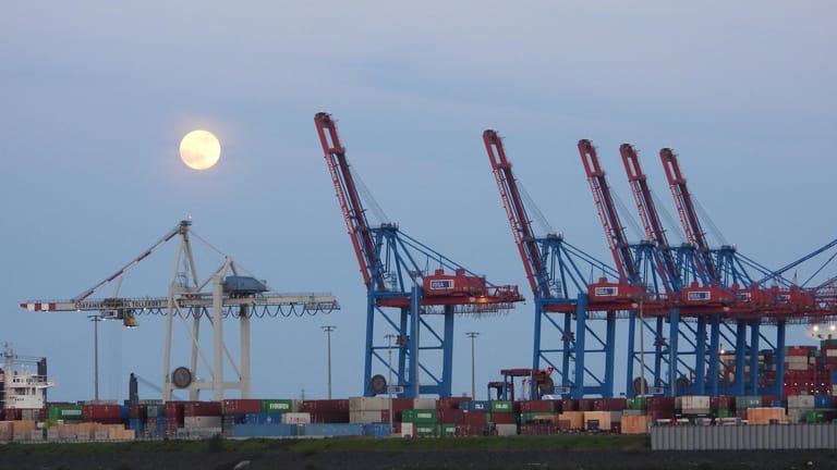 Der Mond über den Kränen des Containerhafens.