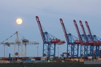 Der Mond über den Kränen des Containerhafens.