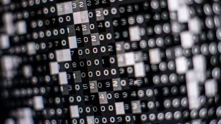 Eine fiktive Hackersoftware verschlüsselt in einer Maske auf dem Bildschirm Daten auf einer Festplatte.