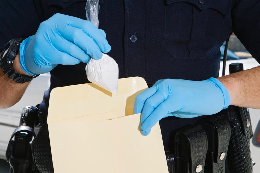 Ein Polizist tütet einen Beutel mit Kokain ein (Symbolbild): Der Drogenbeauftragte nennt die Zahlen "schockierend".