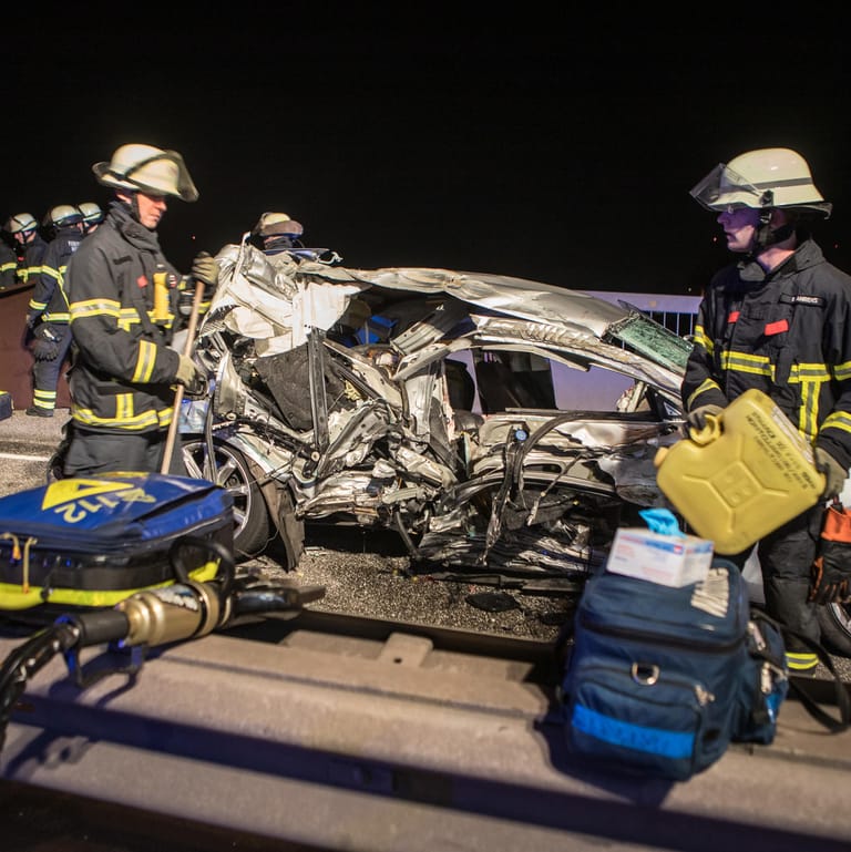 Einsatzkräfte der Feuerwehr stehen neben dem Unfallwagen (Archivbild): Der Fahrer war gegen einen Sattelschlepper gerast.
