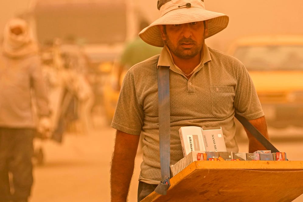 Ein Straßenverkäufer während eines Sandsturms in Bagdad: Die Staubpartikel verschlechtern die Luftqualität deutlich.