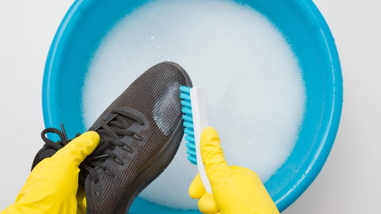 Schuhe reinigen: Spülen Sie Backpulver mit warmem Wasser ab.