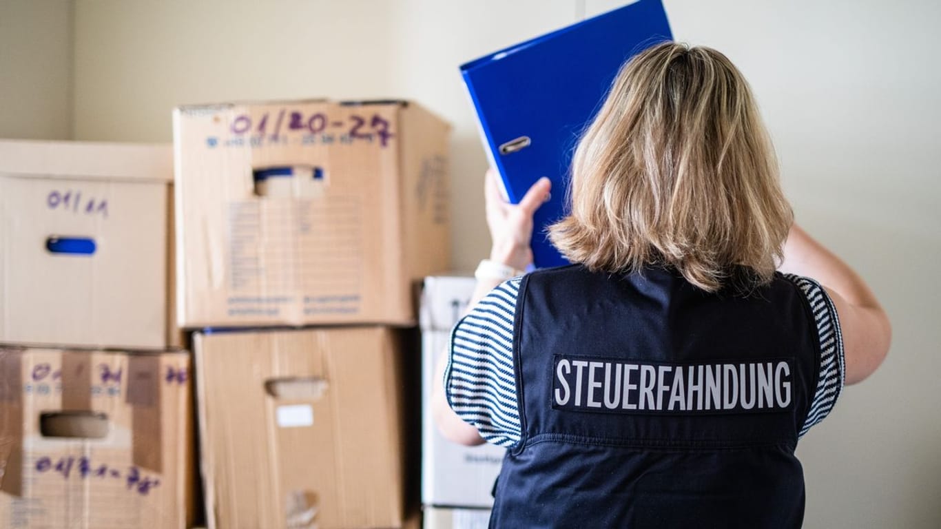 Anhand von sichergestellten Unterlagen machen sich Mitarbeiter der Steuerfahndung auf die Suche nach Indizien für Steuerbetrug.